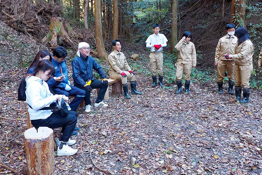 作業後、森の中で休憩する参加者たち