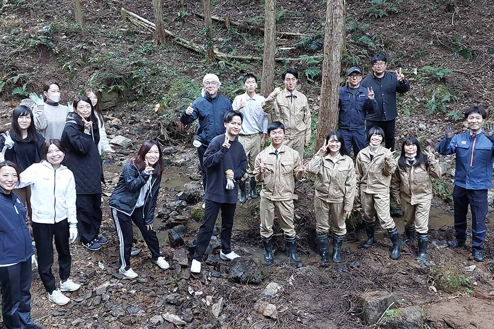 作業後、森の中で休憩する参加者たち