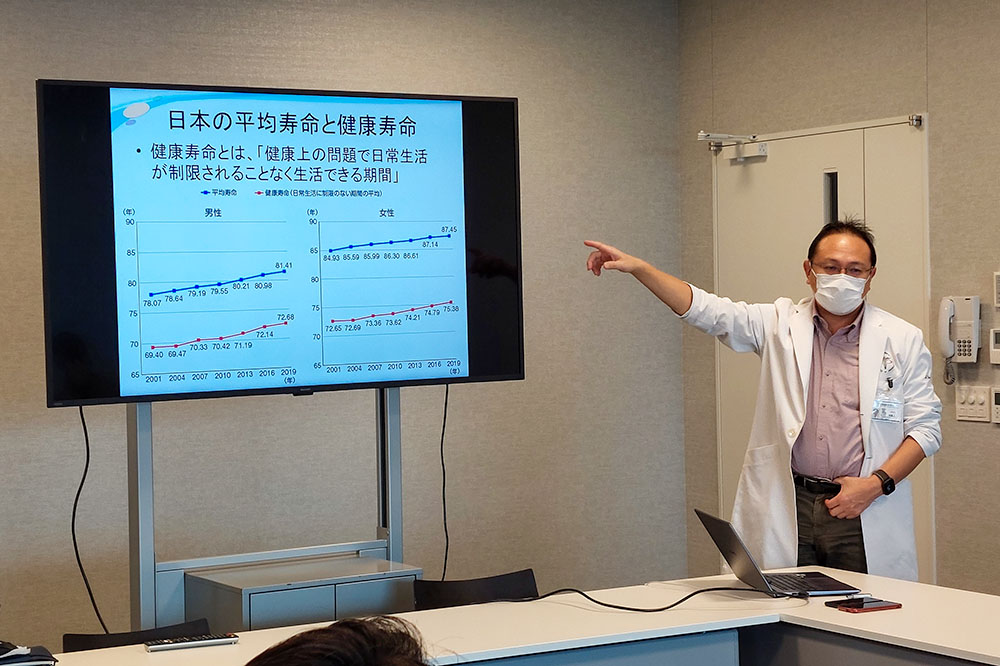 山田先生による健康データの説明を聞く高校生たち