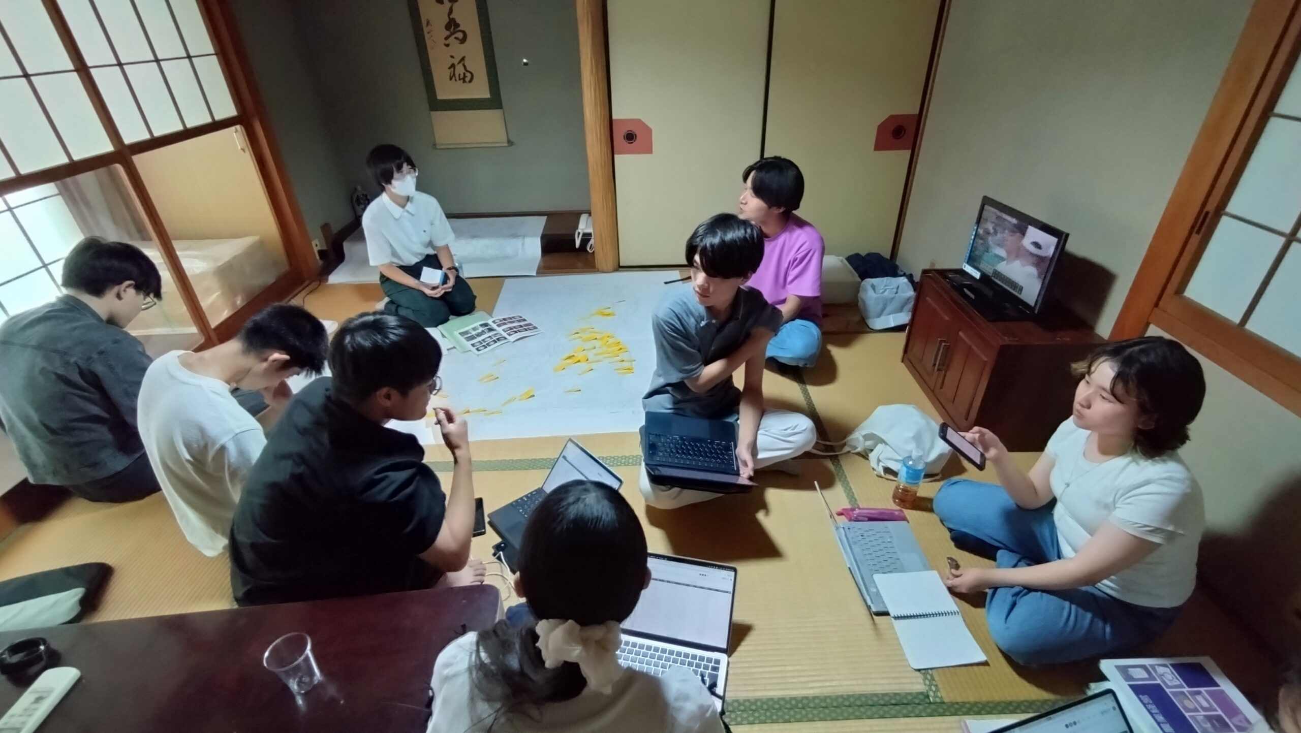 宿泊先で調査結果や発表内容について話し合う学生