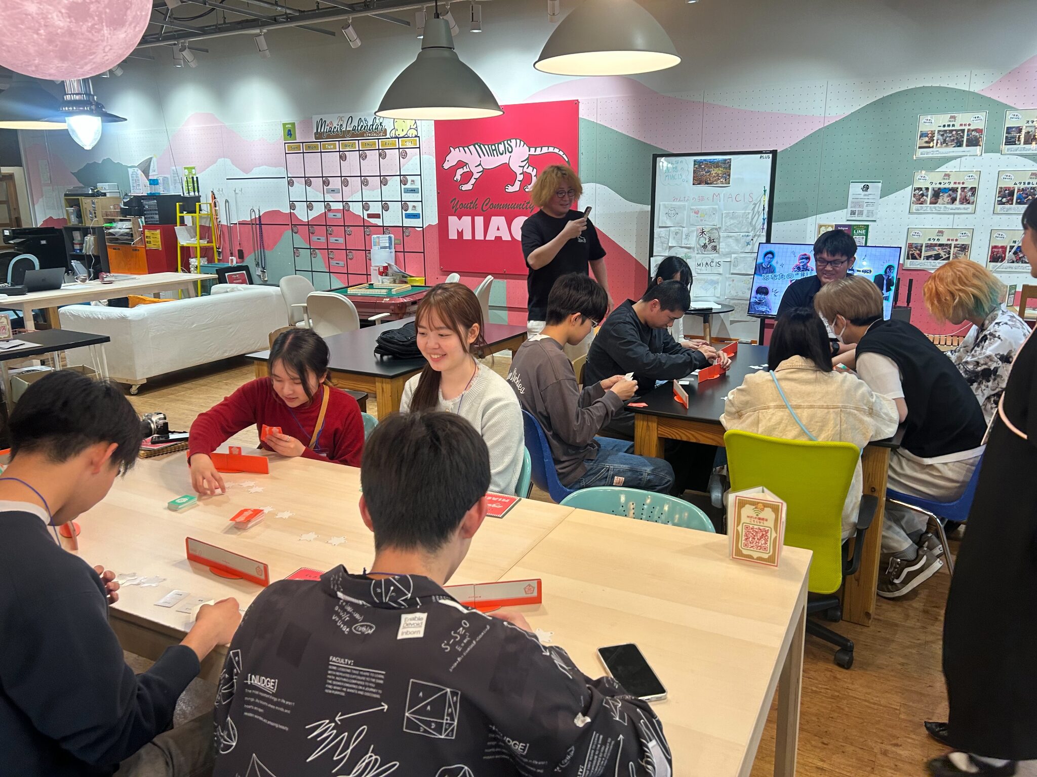 韮崎駅前のユースセンターミアキスで中高生とボードゲームを楽しむ学生
