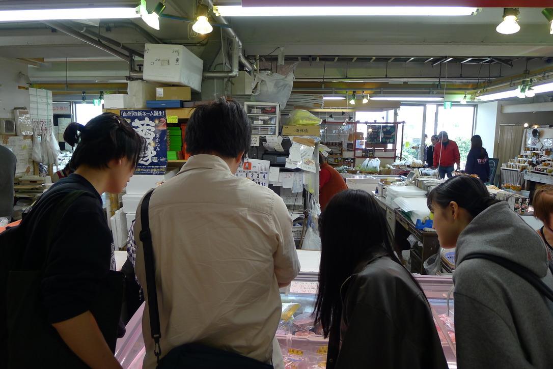 うらりマルシェに並ぶ地域の水産物や加工品を見学する学生