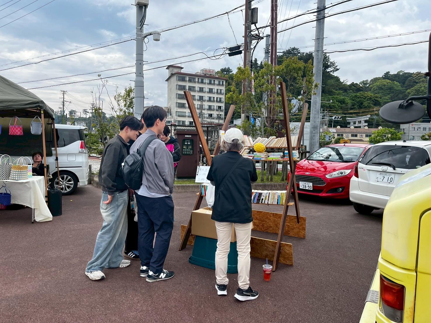 古材で作った販売ブースを使って古本市を運営する学生