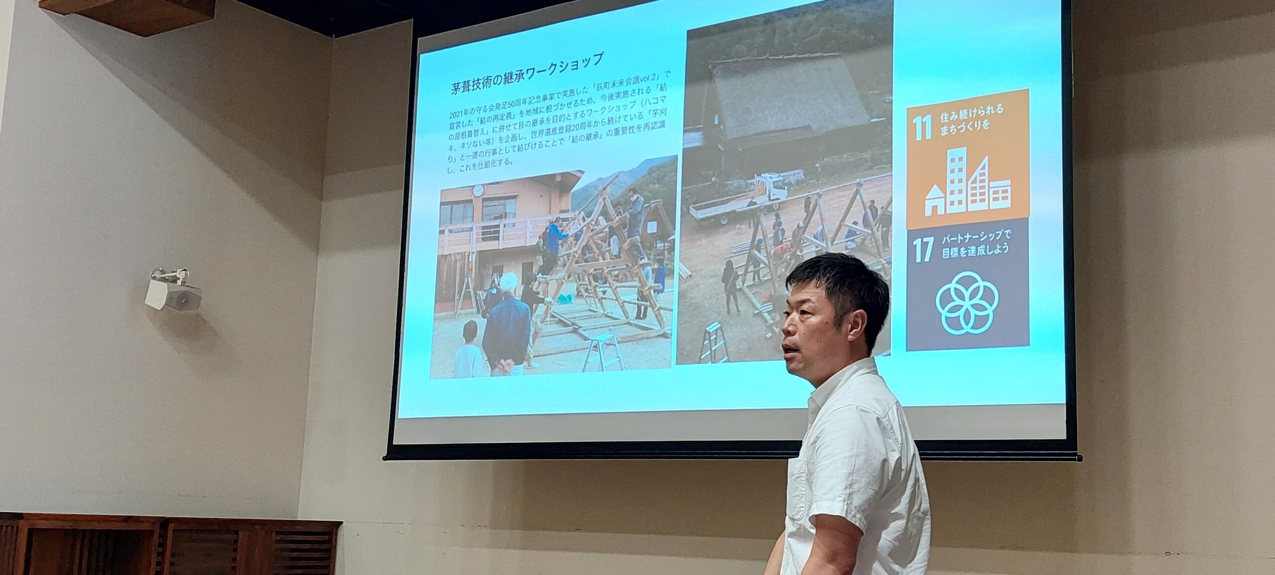 白川郷研修で茅葺き技術の継承について講話を聞く様子