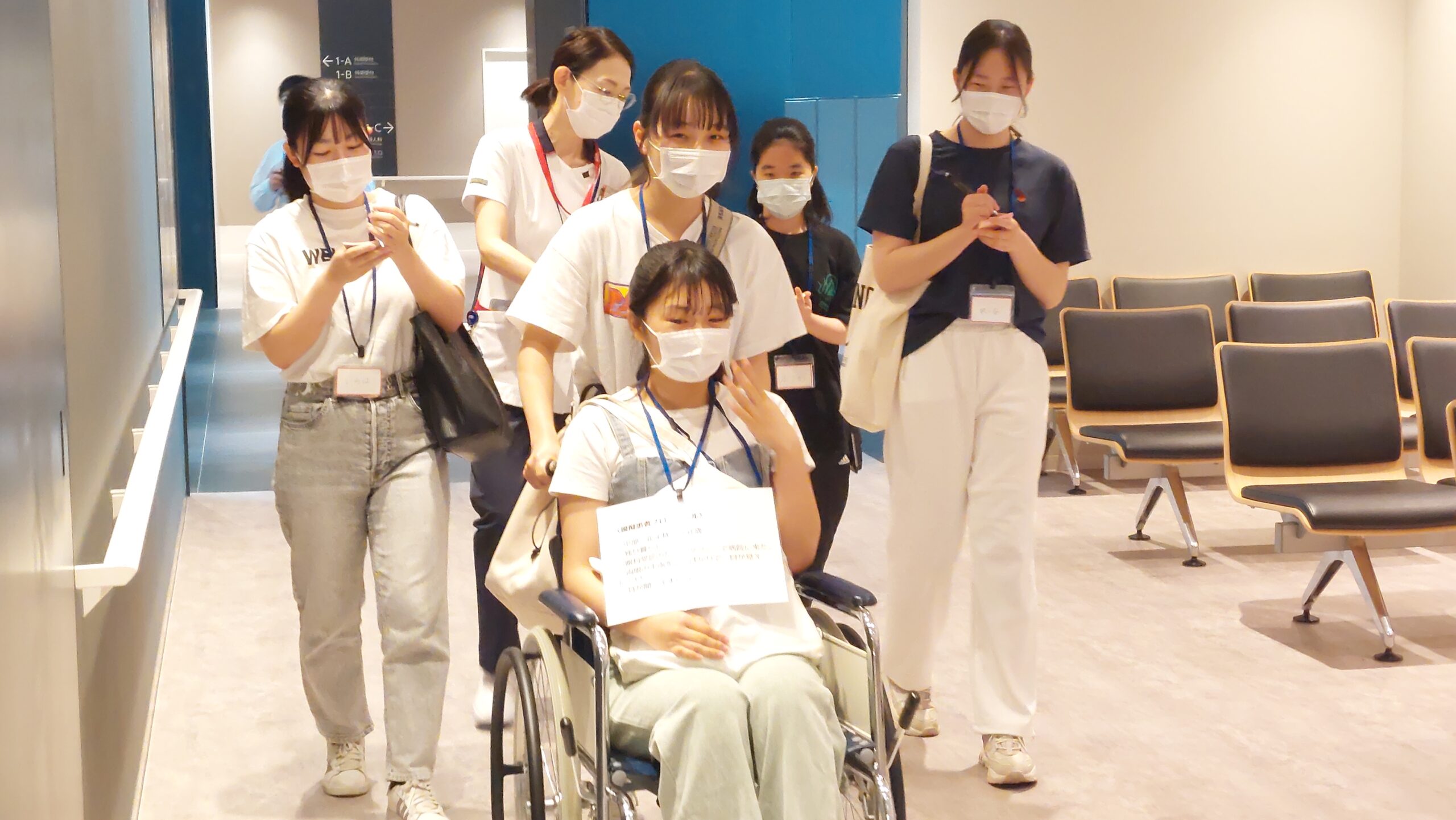 患者役の高校生が車椅子に乗り、別の高校生が押している様子