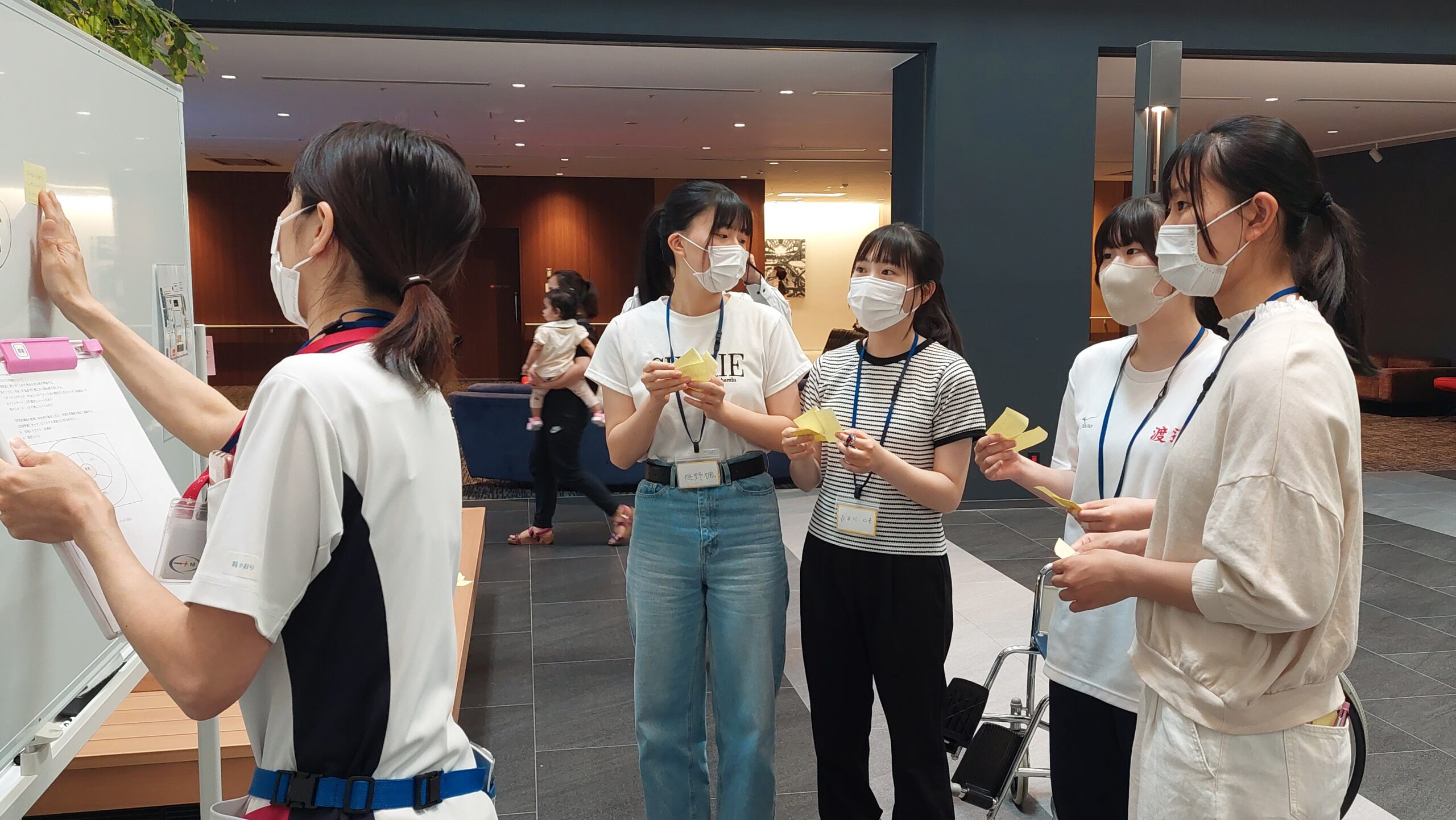 看護師がホワイトボードに付箋を貼りながら高校生と気づきを共有している様子
