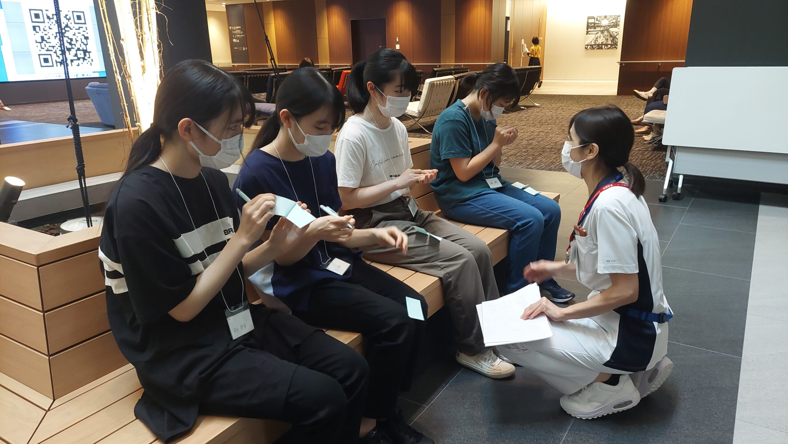 高校生が付箋に気づきを書きながら看護師と話している様子