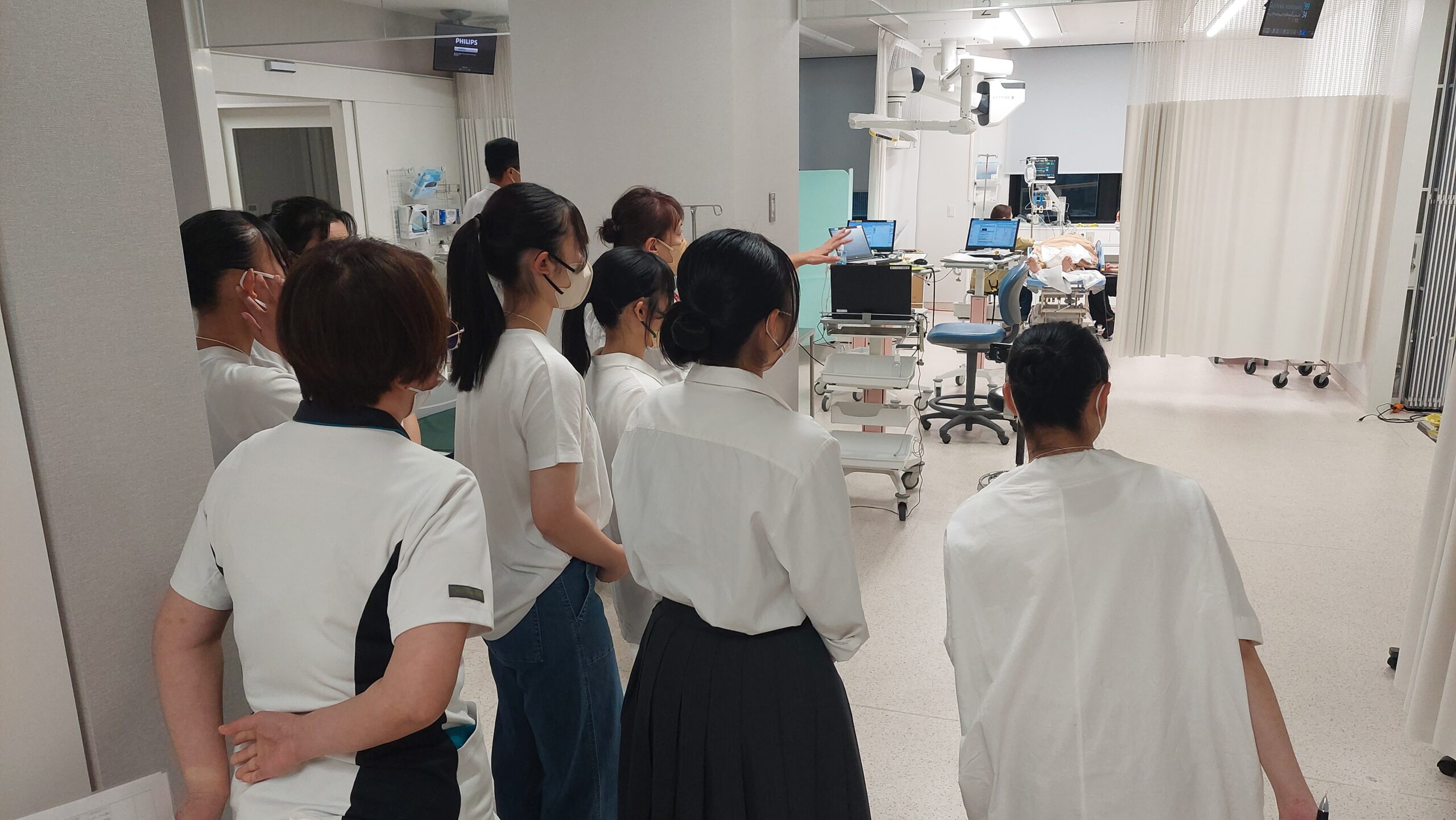 現役看護師の案内で高校生が院内の医療現場を見学している様子