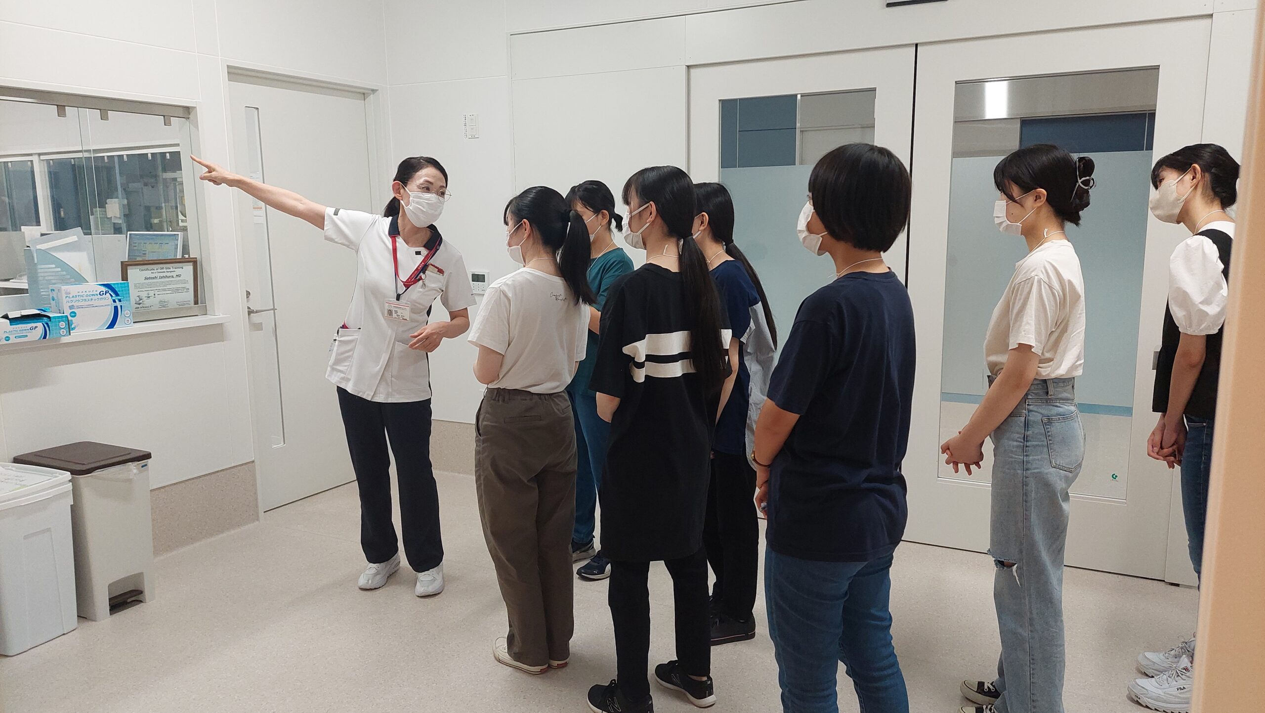 院内で看護師から設備について説明を受ける高校生