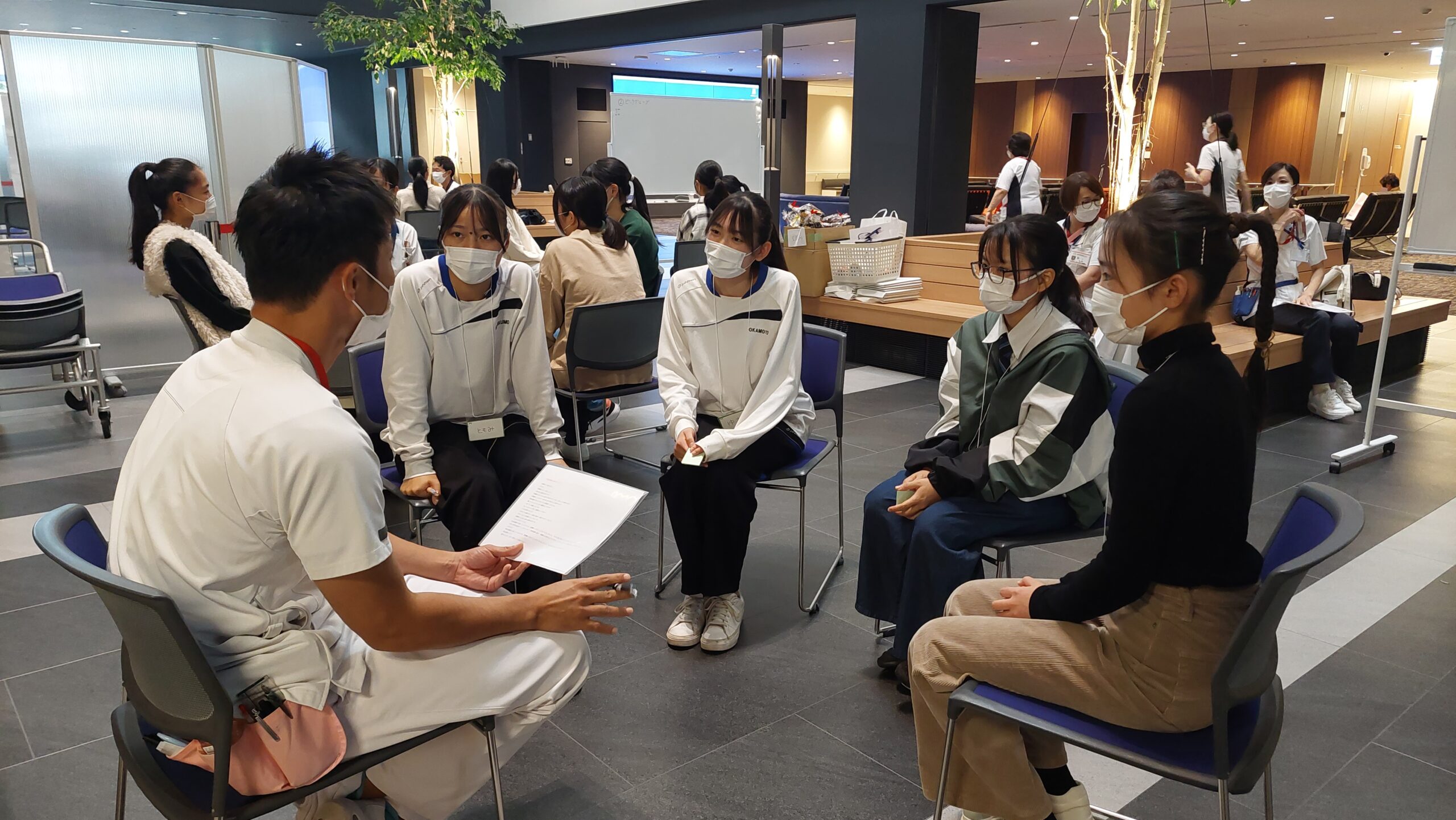 現役看護師の案内で高校生が院内を見学している様子