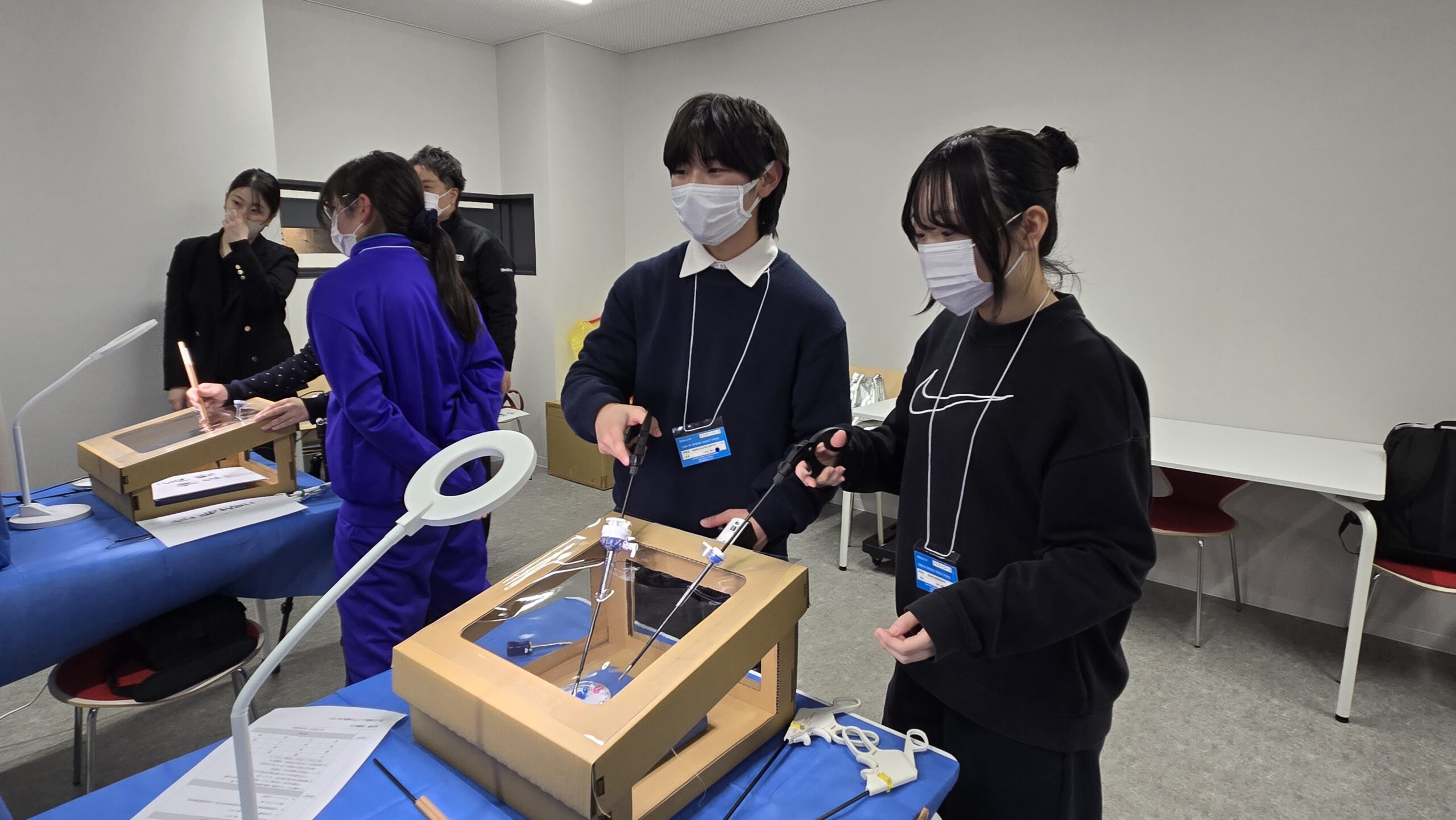 内視鏡手術を想定したトレーニング機器を操作する高校生