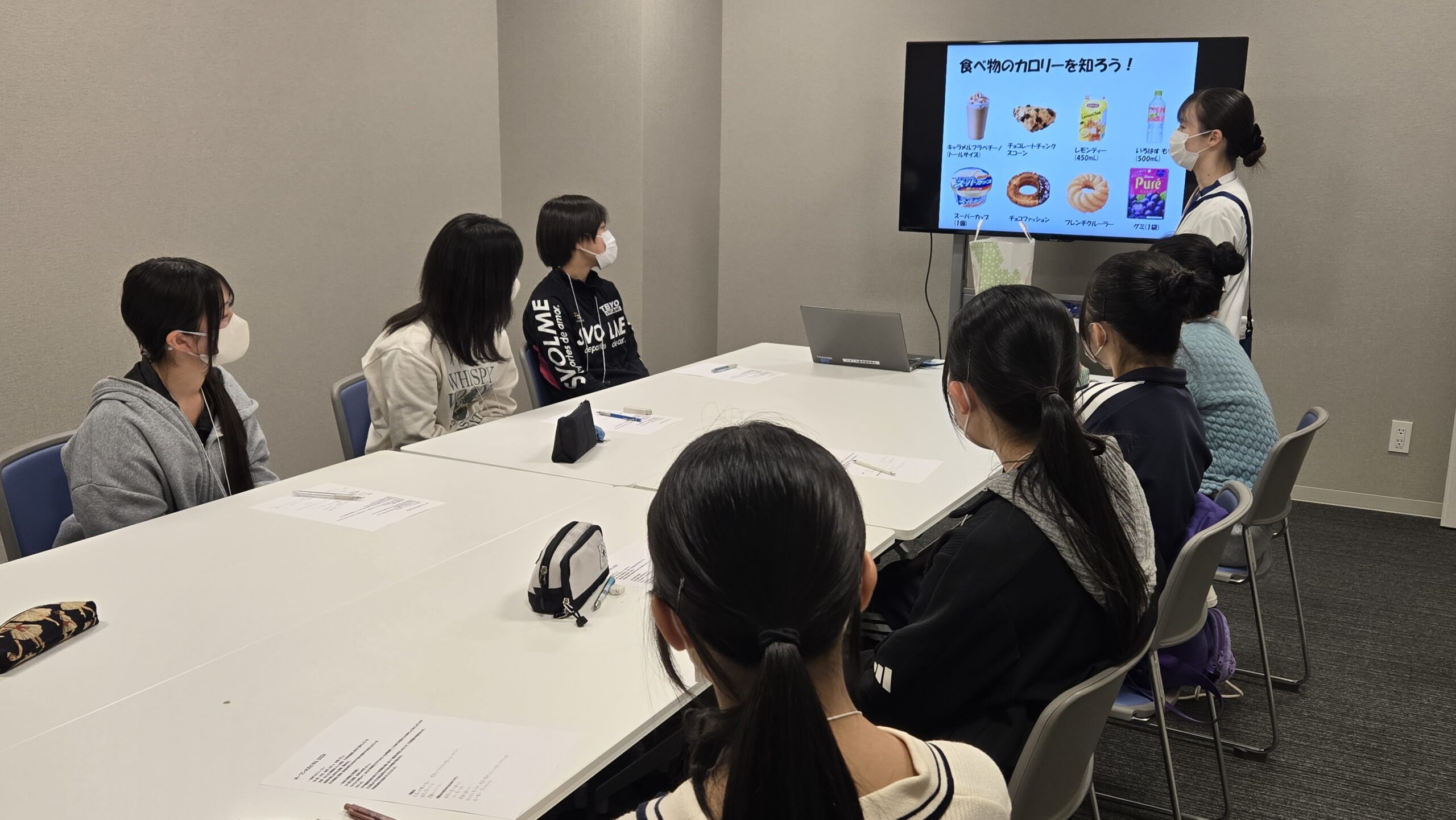 食品のカロリーについて管理栄養士から説明を受ける高校生