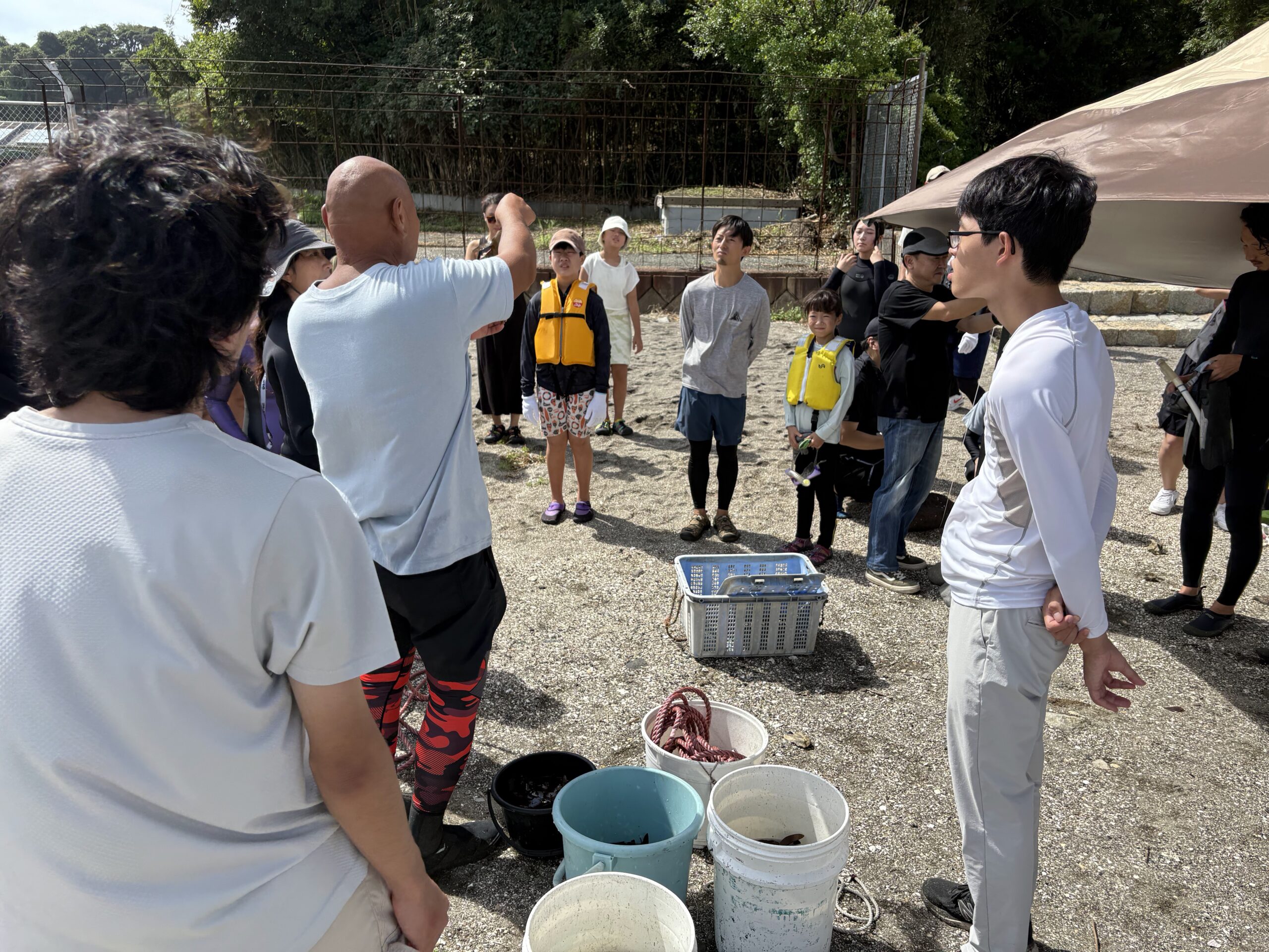 藻場保全活動について海岸で説明を受ける参加者