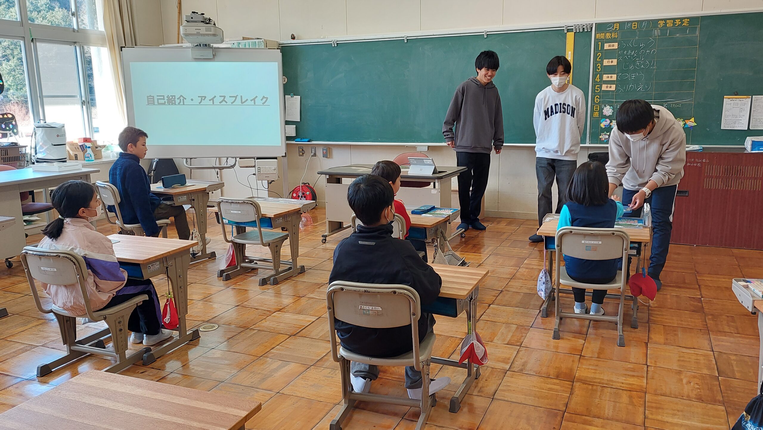 三和小学校の教室で自己紹介とアイスブレイクを行う加茂高校の高校生