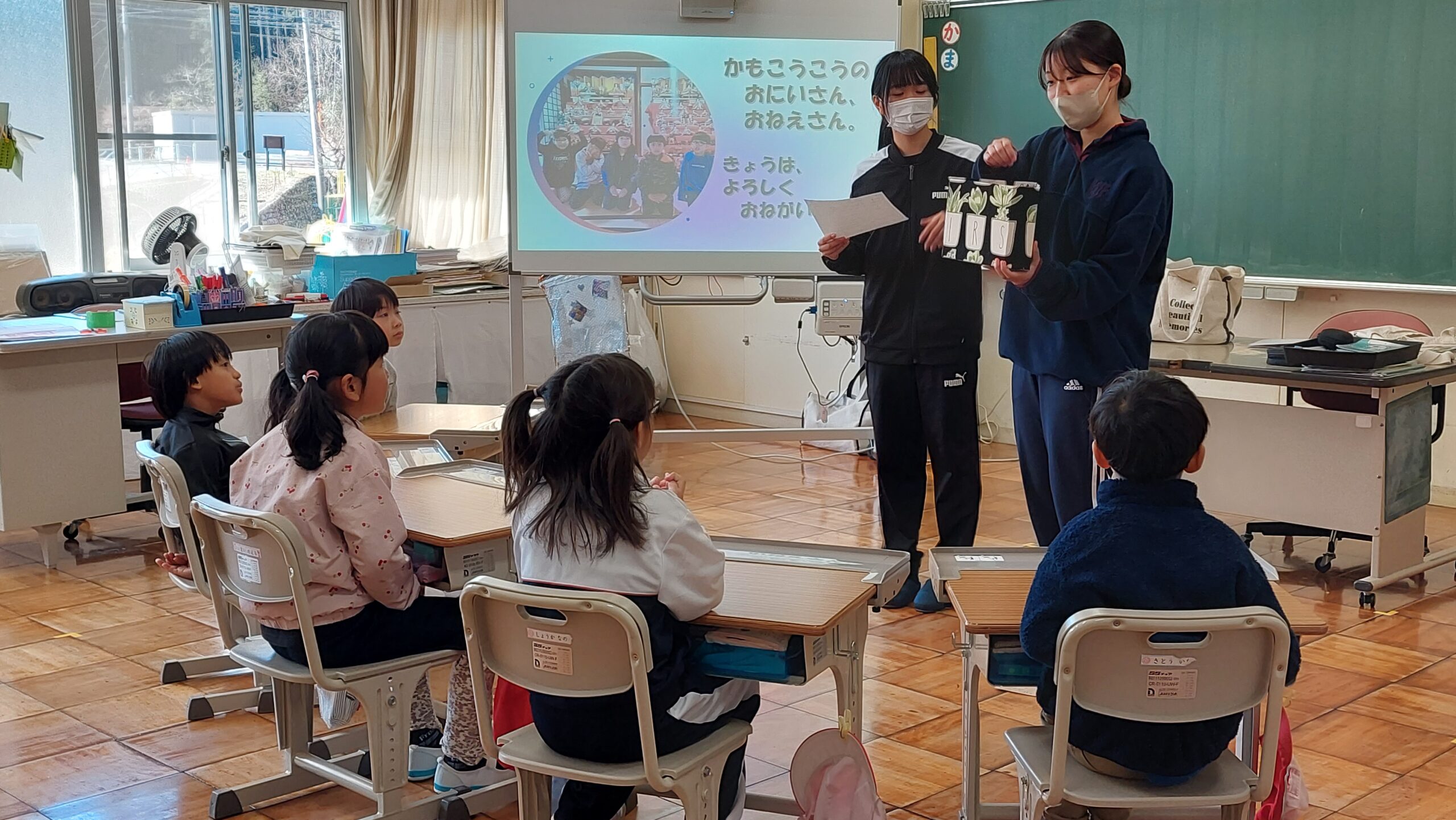 小学生へ手作り教材を示しながら活動する加茂高校の高校生