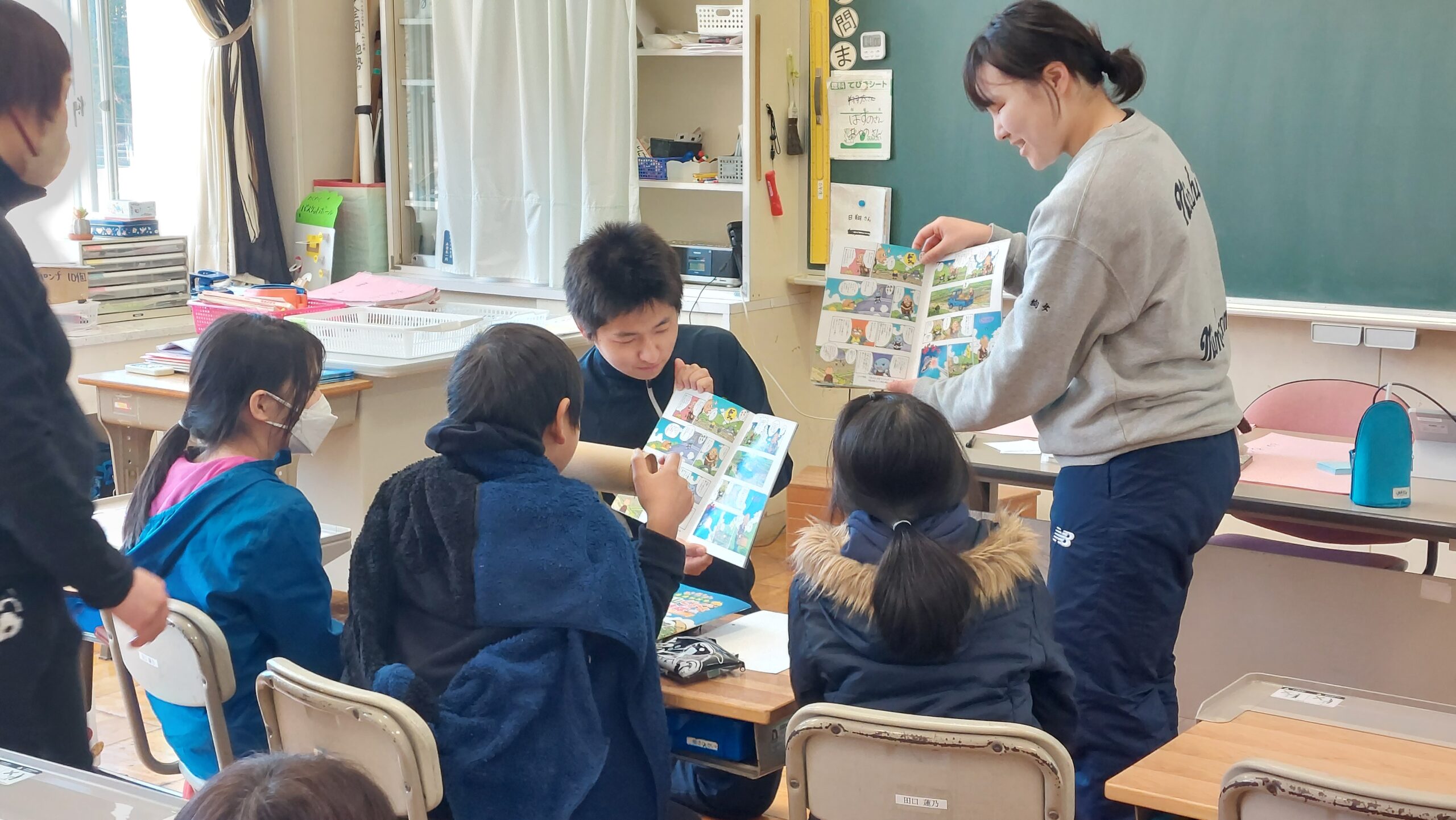 マンガ教材を囲みながら小学生と内容を考える加茂高校の高校生