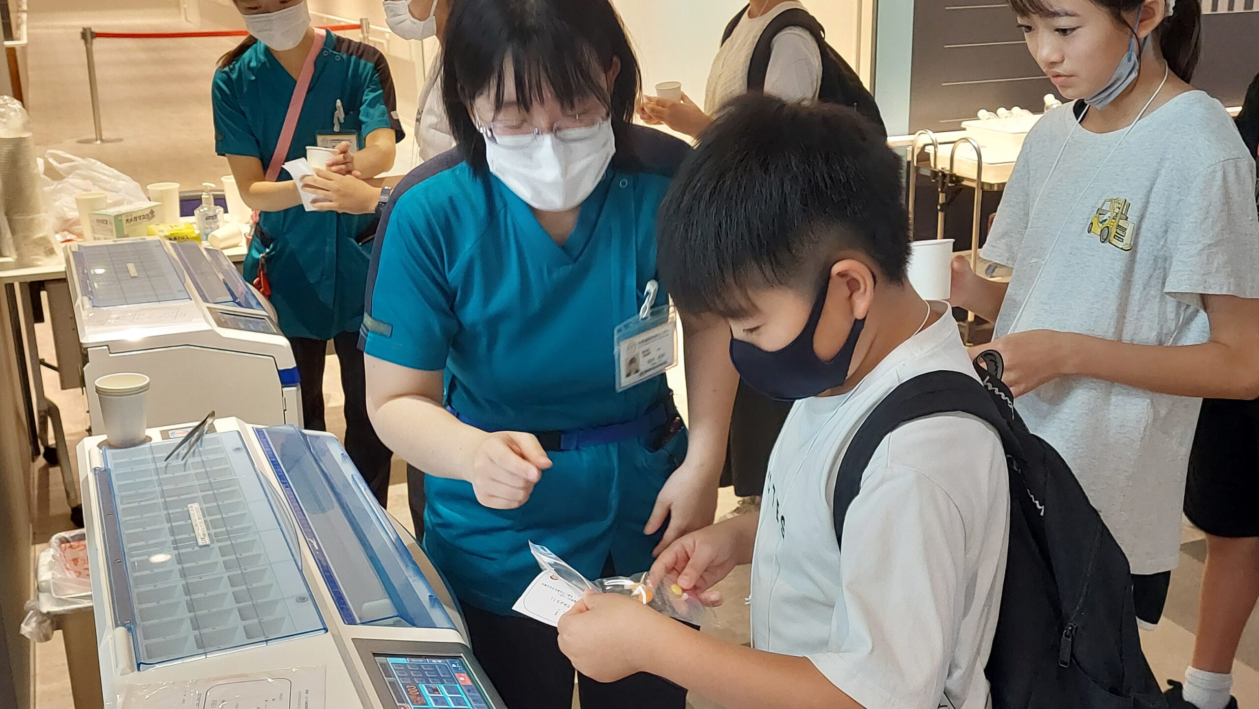 医療スタッフから医療現場で使われる機器や道具について教わる小学生