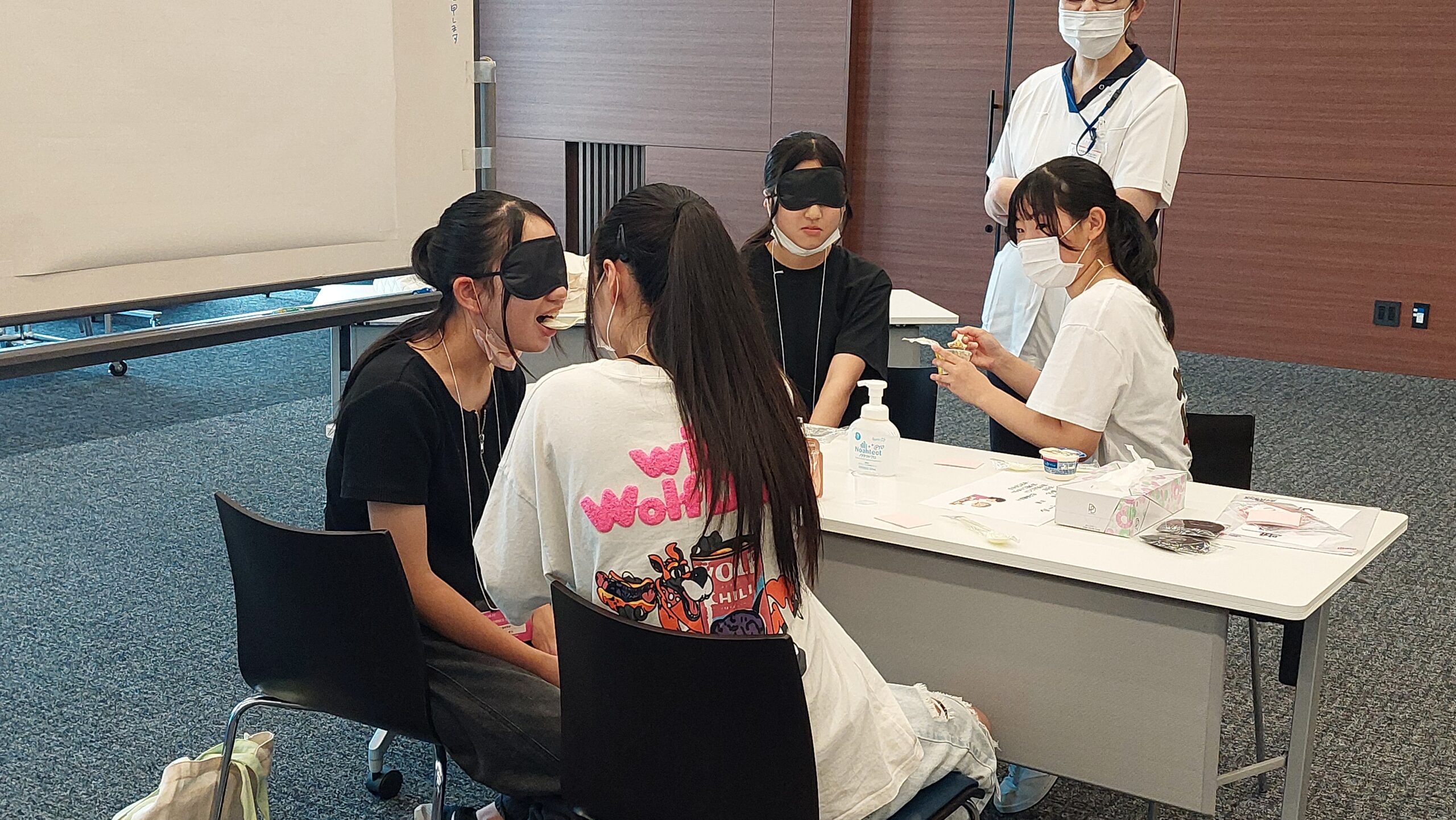 視覚を制限した状態で患者側の感覚について考える高校生