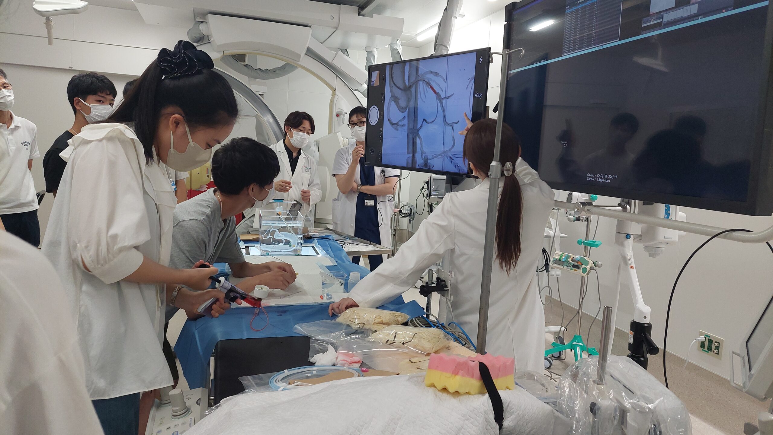 医療従事者から医療機器や専門技術について説明を受ける高校生