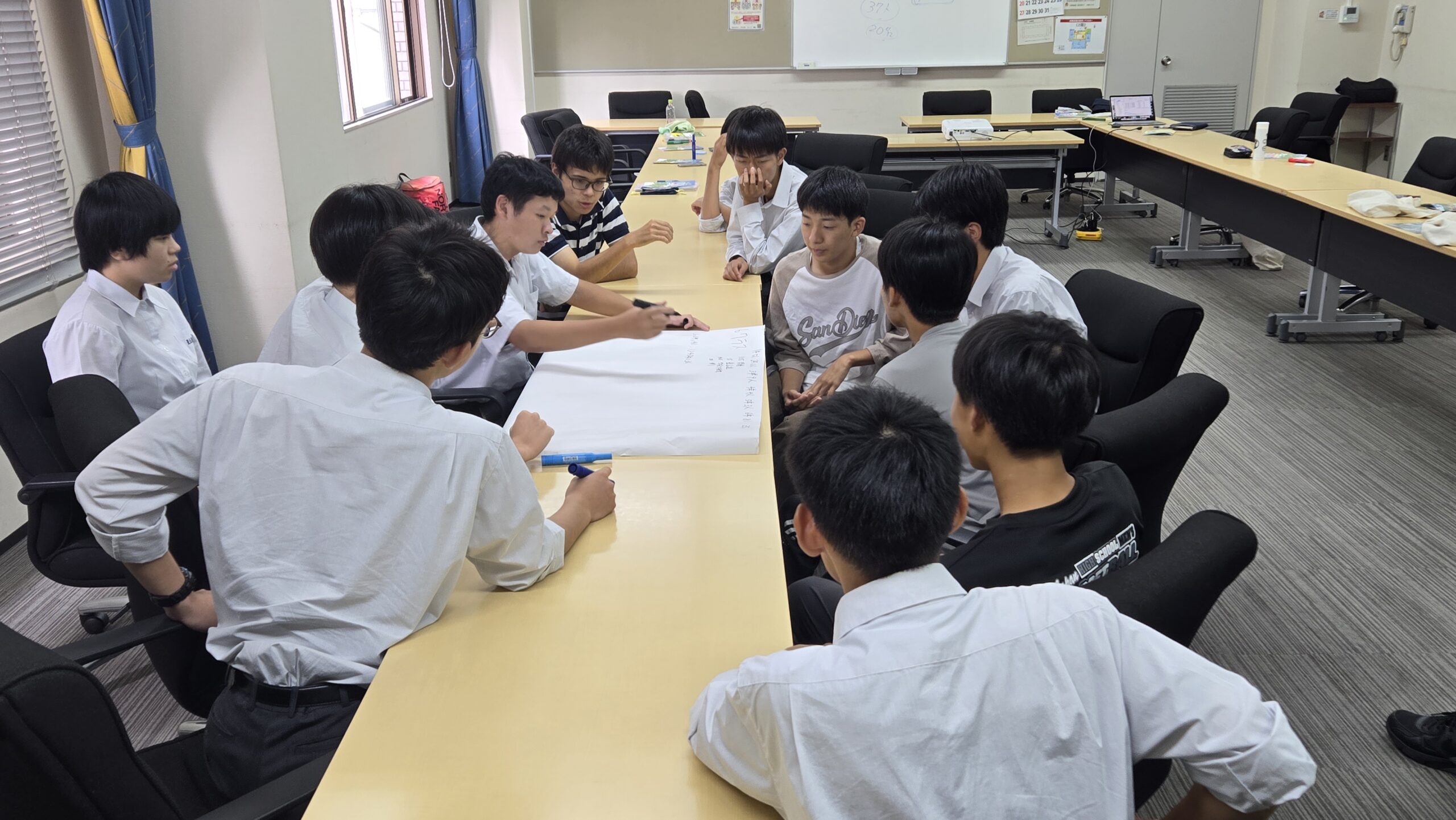 模造紙を囲みながら授業のアイデアについて話し合う加茂高校の高校生