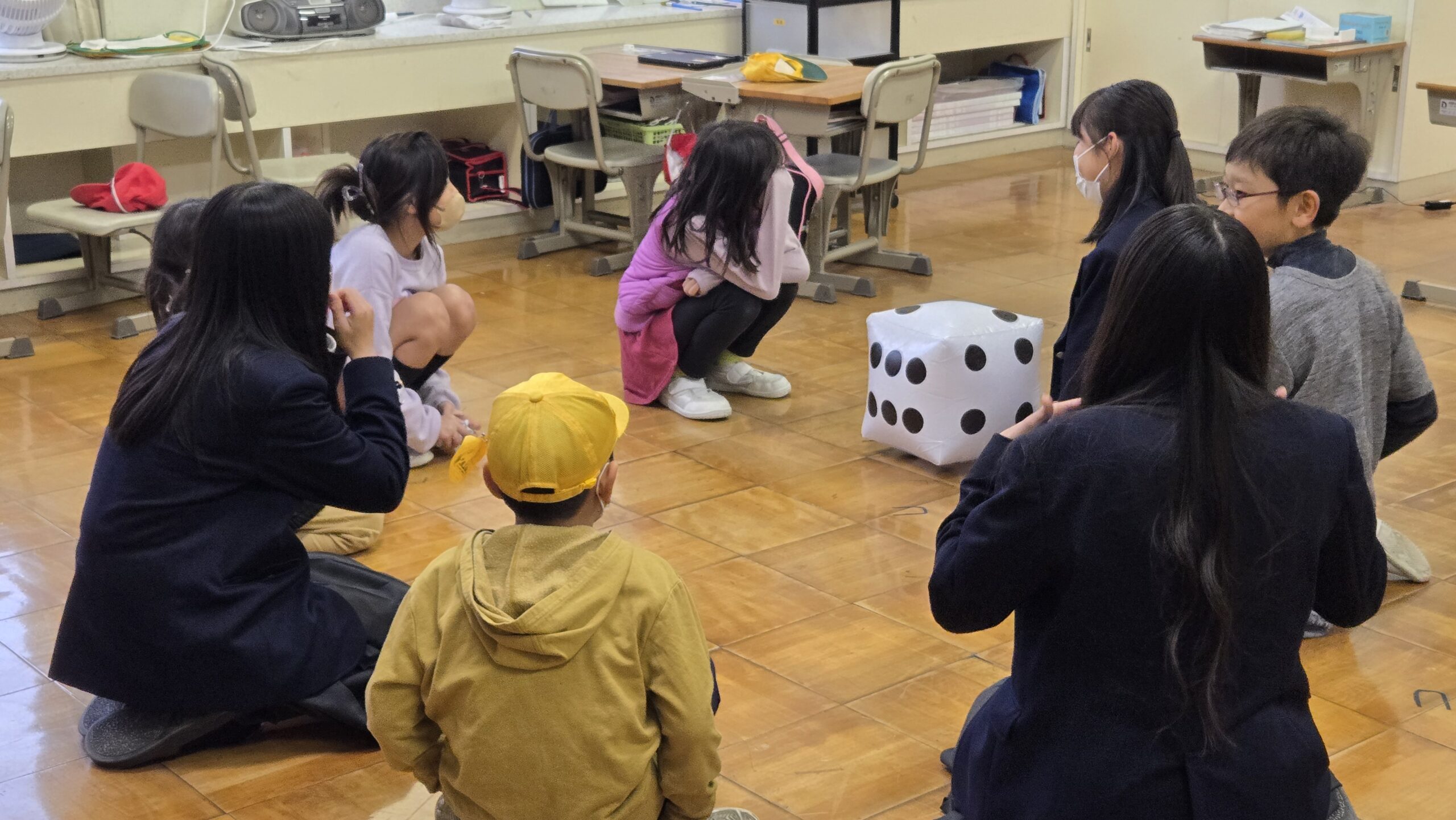 ゲームを取り入れたアイスブレイクを行う高校生と小学生