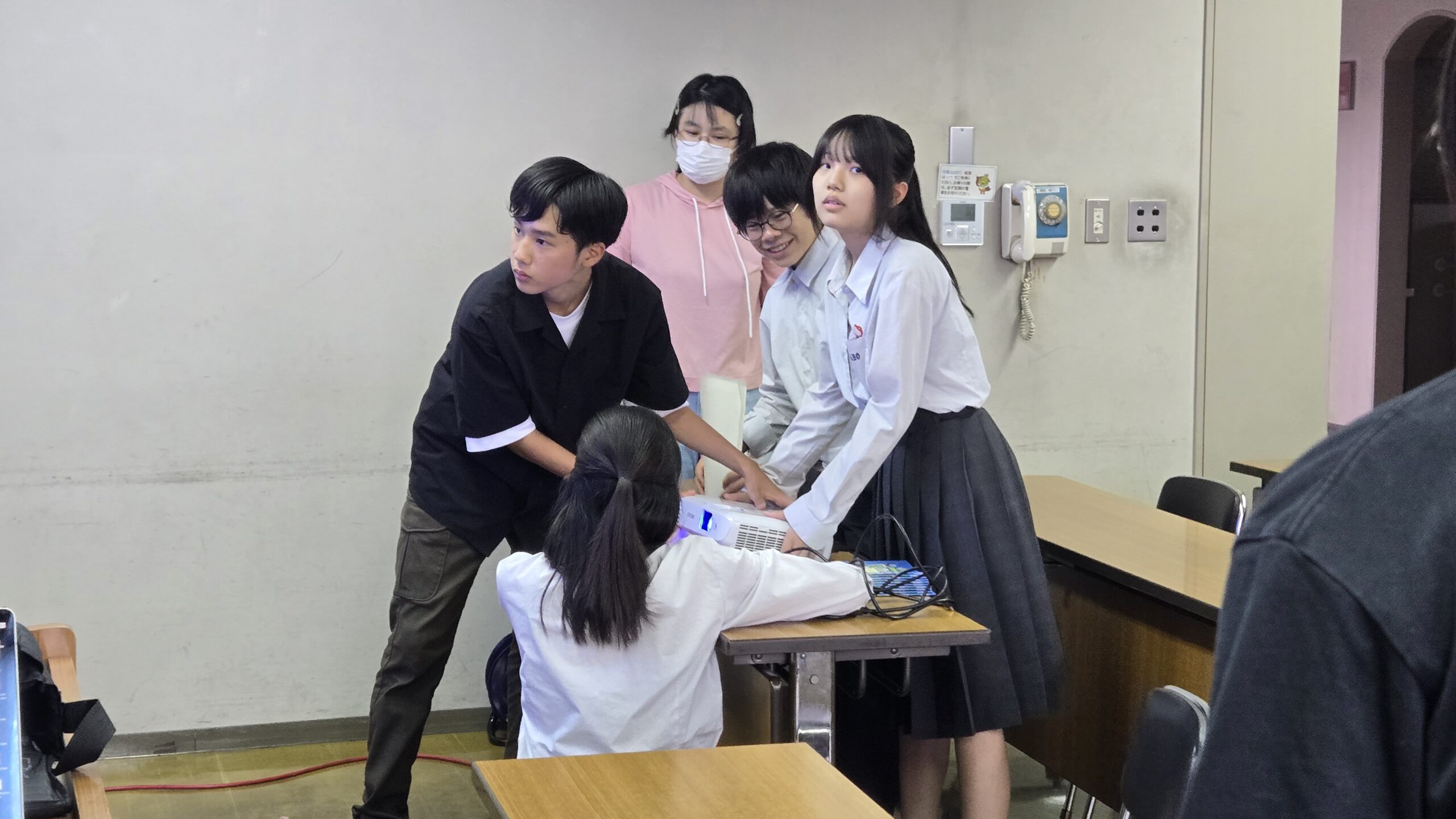 プロジェクターを設置する高校生たち