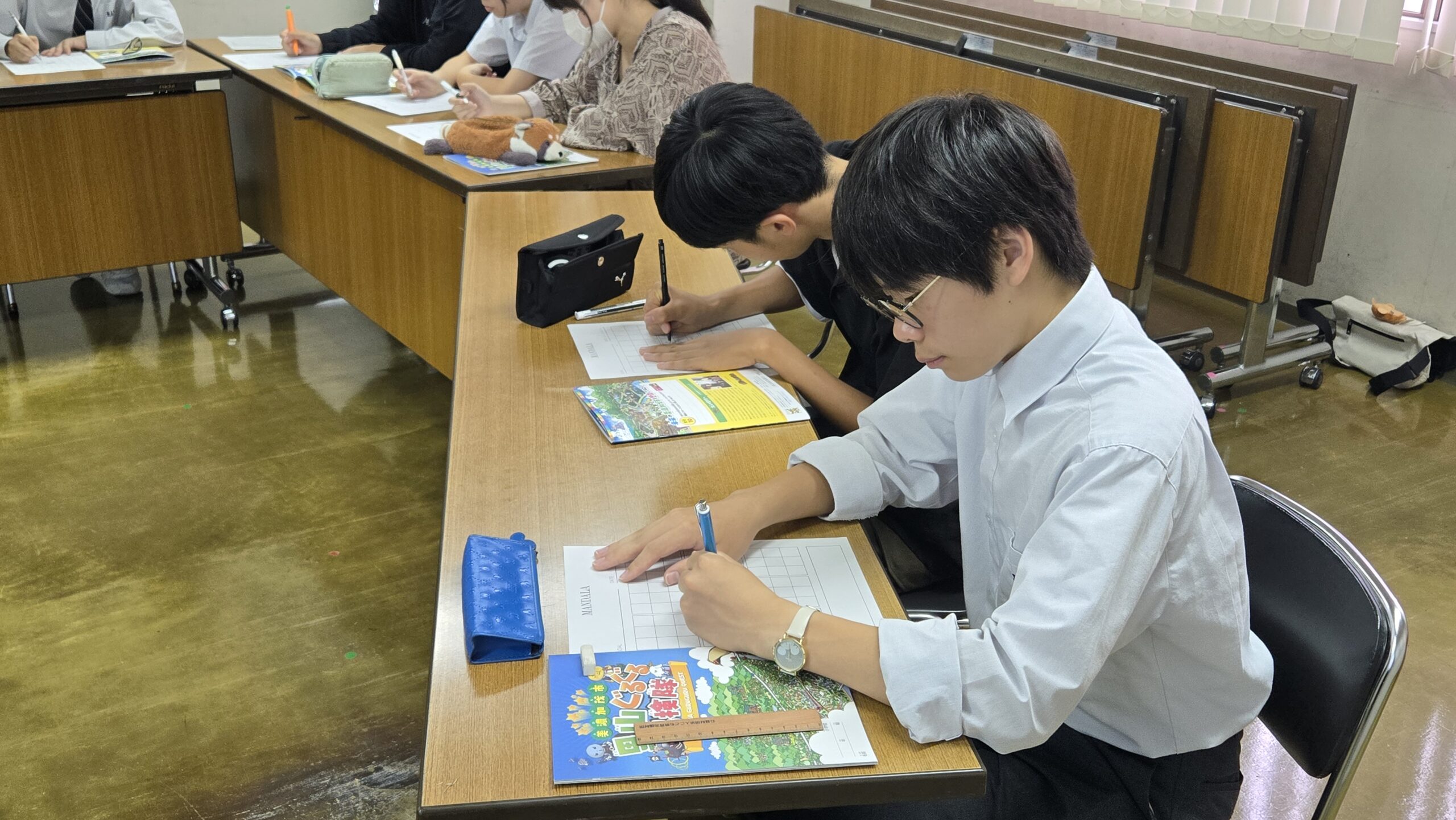 授業アイデアをマンダラ用紙へ整理する高校生