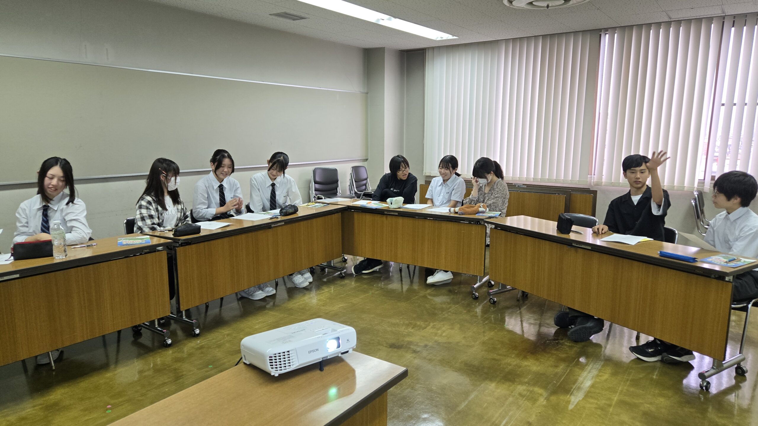 用紙へアイデアを書き込みながら話し合う高校生たち