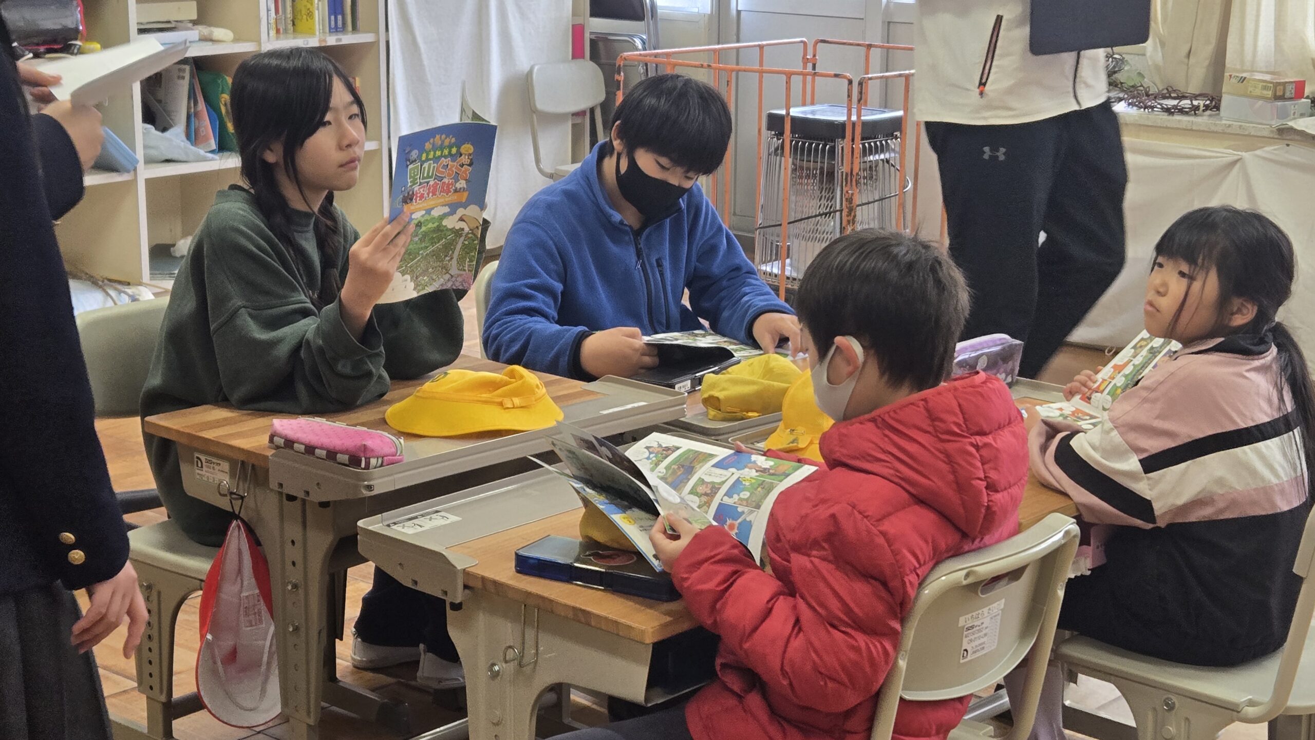 マンガ教材を見せながら小学生と話す高校生