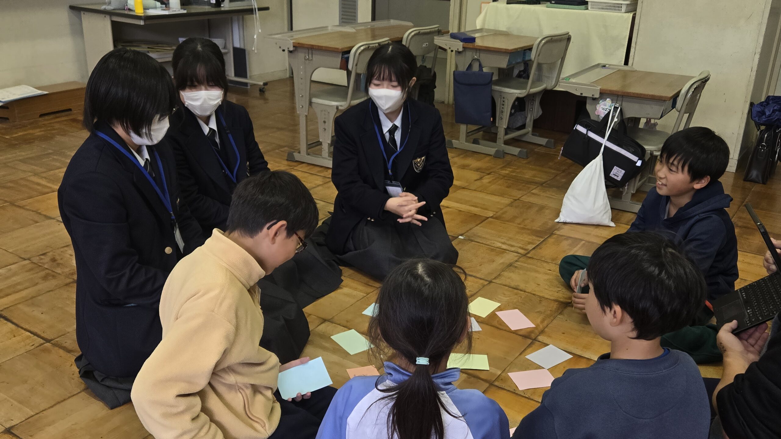 カードを使ったゲームで小学生と交流する高校生