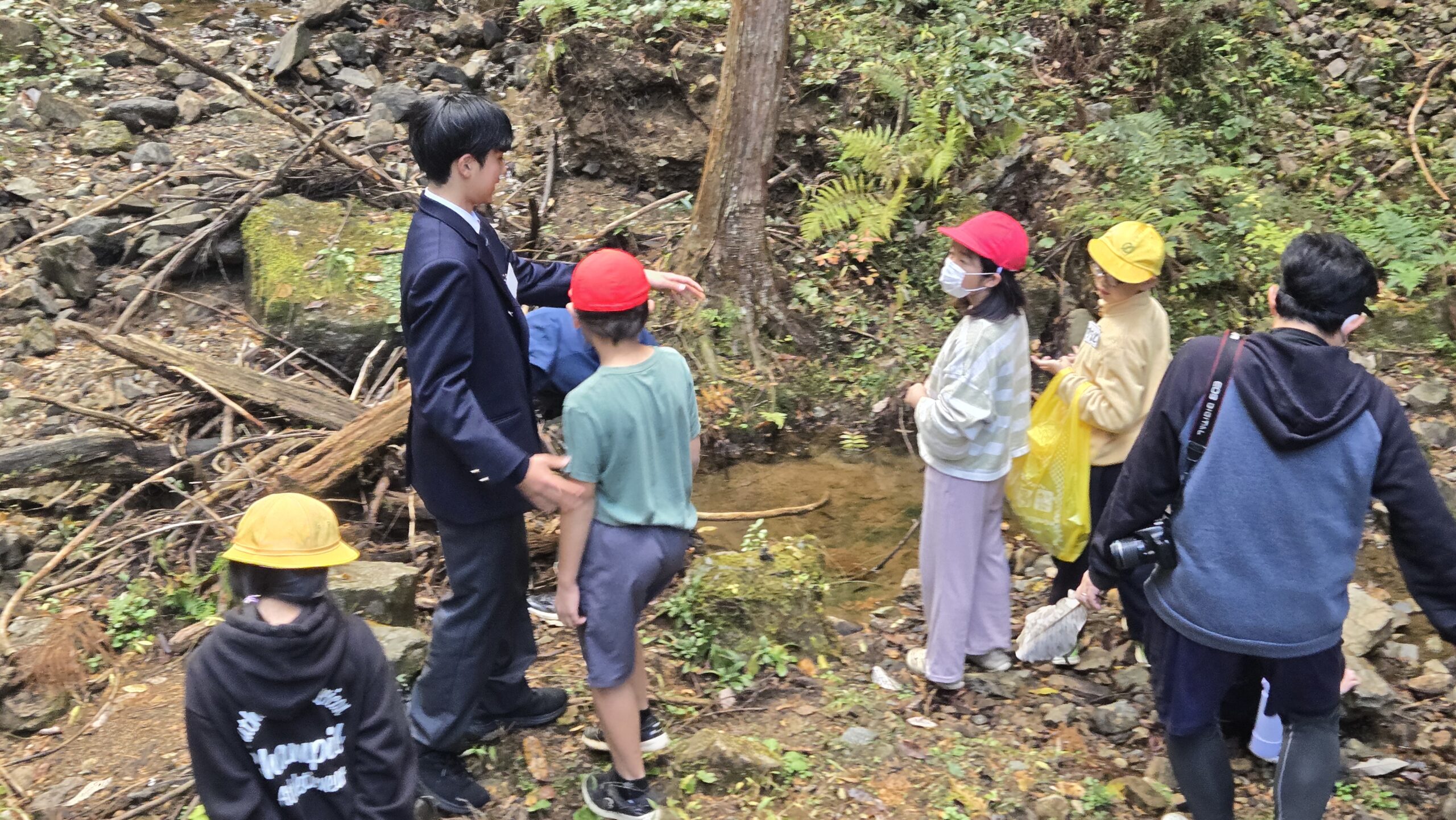 林道で小学生へ説明する高校生