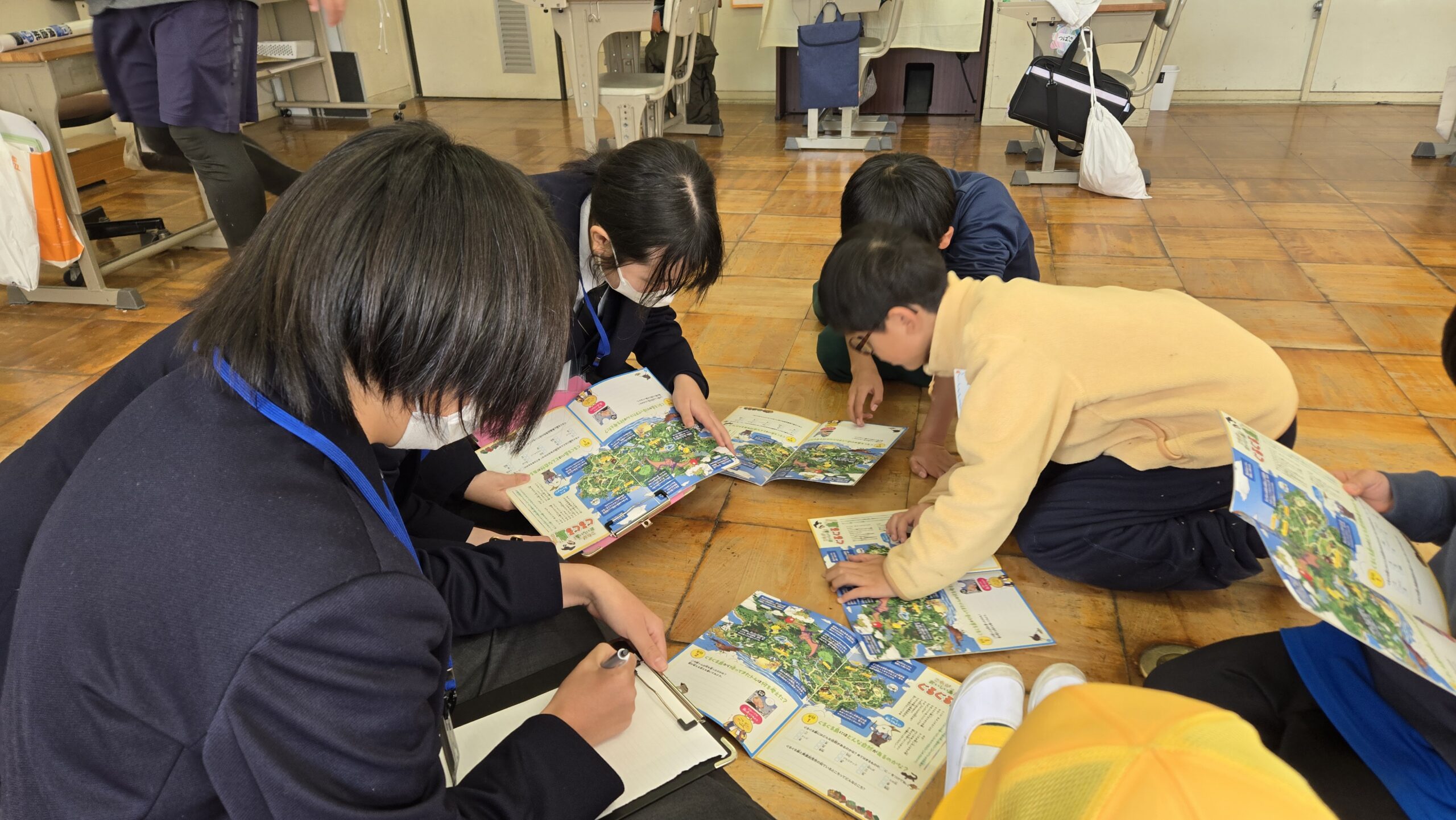 マンガ教材を広げながら高校生と小学生が話す様子